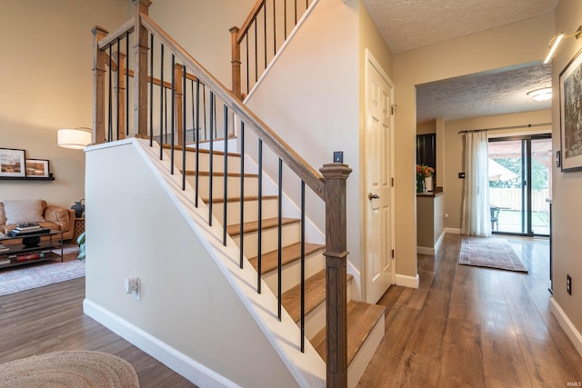 stairs featuring hardwood / wood-style flooring and a textured ceiling