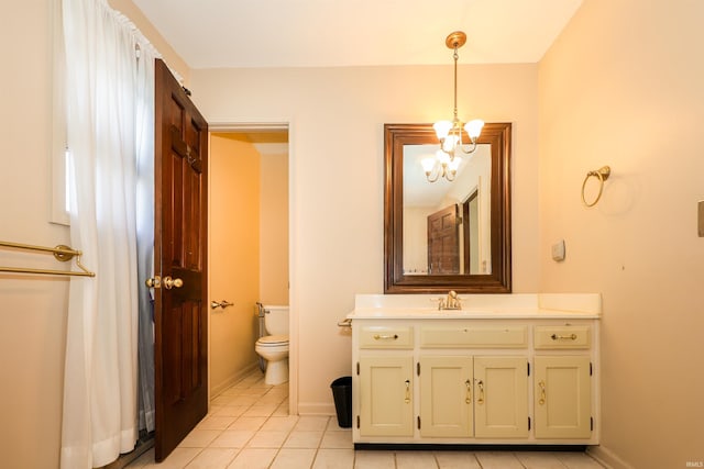 bathroom with tile patterned flooring, vanity, a notable chandelier, and toilet