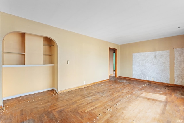 spare room featuring hardwood / wood-style flooring and built in features