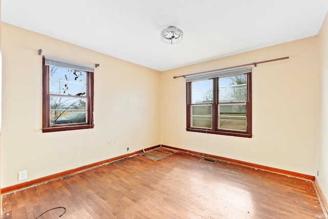 unfurnished room with hardwood / wood-style flooring