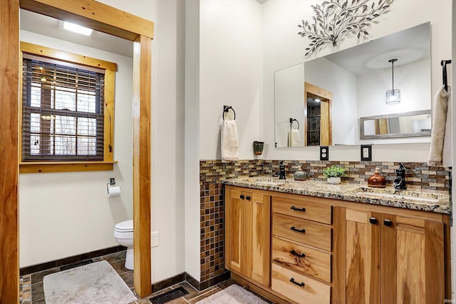 bathroom featuring vanity, tile walls, and toilet