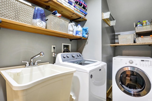 clothes washing area featuring sink and washer and dryer