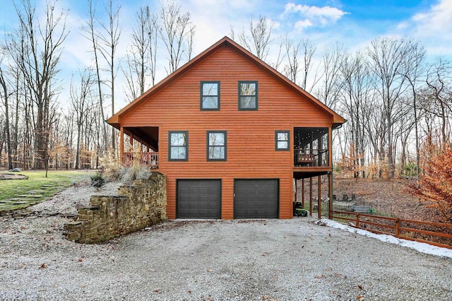 view of side of home with a garage and a sunroom