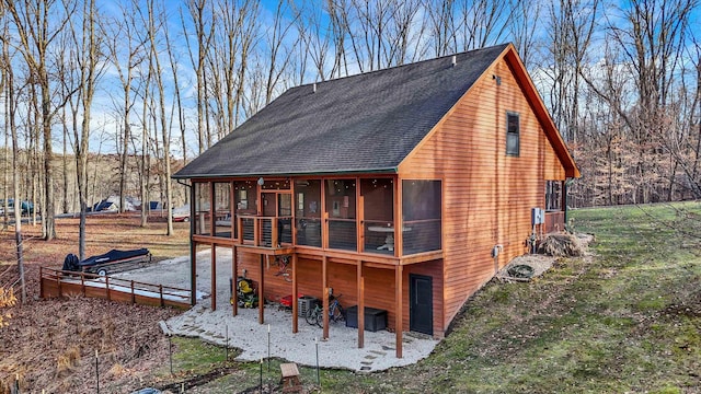 rear view of property with a patio, a sunroom, and a lawn