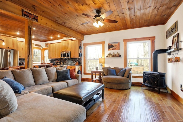 living room with wood ceiling, plenty of natural light, and light wood-type flooring