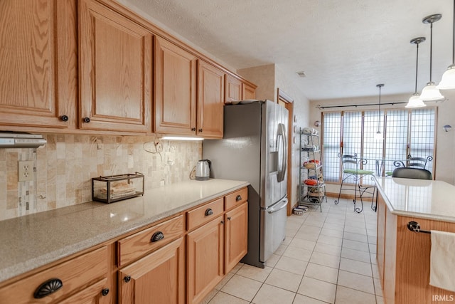 kitchen with decorative light fixtures, decorative backsplash, light tile patterned floors, stainless steel fridge with ice dispenser, and a textured ceiling