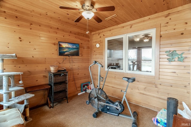 workout area with ceiling fan, wood walls, and wooden ceiling