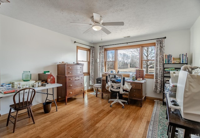 office space with a textured ceiling, light hardwood / wood-style flooring, and ceiling fan