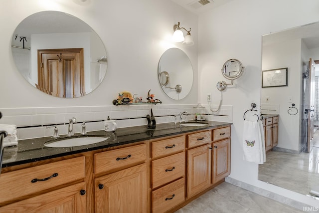 bathroom featuring tile patterned floors, vanity, and decorative backsplash