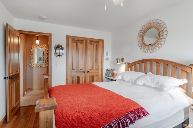 bedroom with ceiling fan, light hardwood / wood-style floors, and a closet