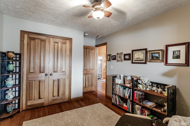 interior space featuring ceiling fan, dark hardwood / wood-style flooring, and a textured ceiling