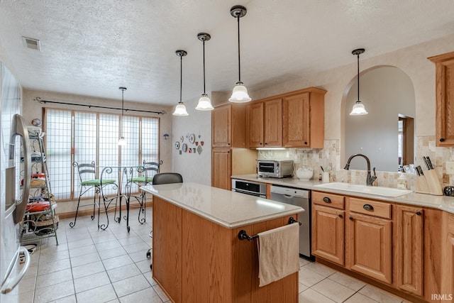 kitchen featuring appliances with stainless steel finishes, sink, and decorative light fixtures