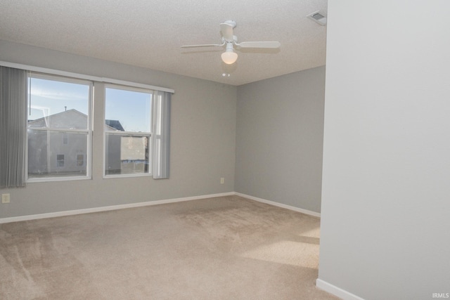 unfurnished room featuring light carpet, a textured ceiling, and ceiling fan