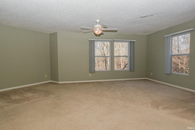 carpeted spare room with a textured ceiling and ceiling fan