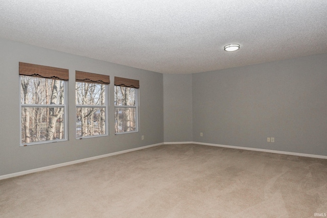 carpeted empty room featuring a textured ceiling