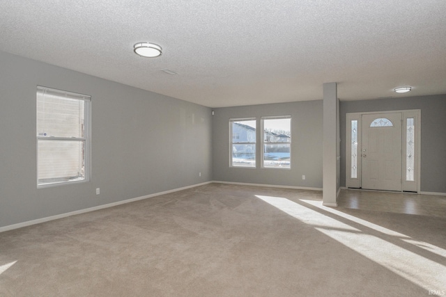 carpeted foyer featuring a textured ceiling