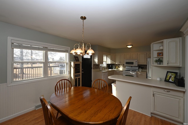 dining space with a chandelier, sink, and light wood-type flooring