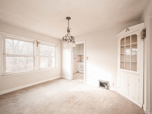 carpeted empty room featuring a textured ceiling