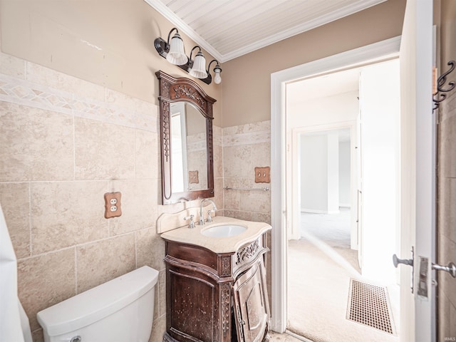 bathroom with tile walls, vanity, ornamental molding, and toilet