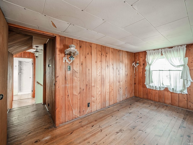 spare room featuring hardwood / wood-style floors and wood walls