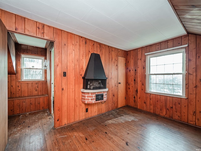 unfurnished living room featuring wooden walls and dark hardwood / wood-style floors