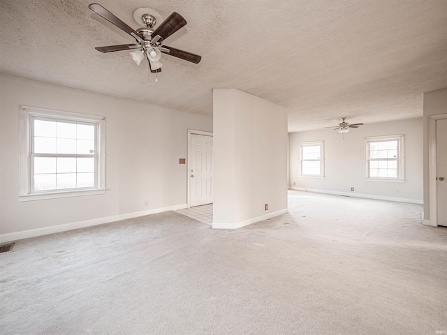 carpeted spare room with a textured ceiling and ceiling fan