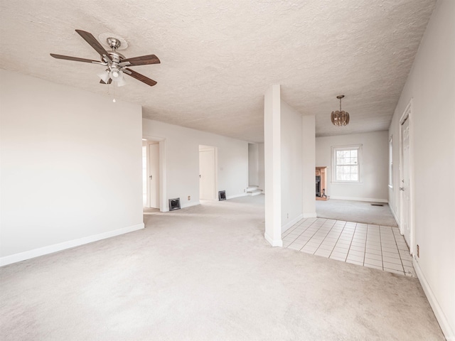 carpeted spare room with ceiling fan and a textured ceiling