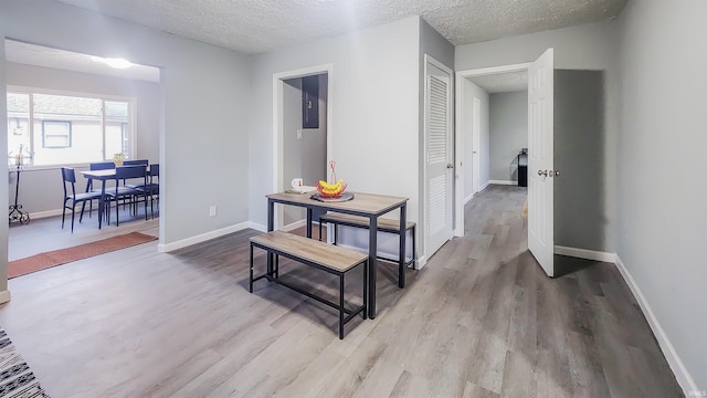 hall with a textured ceiling and light hardwood / wood-style floors