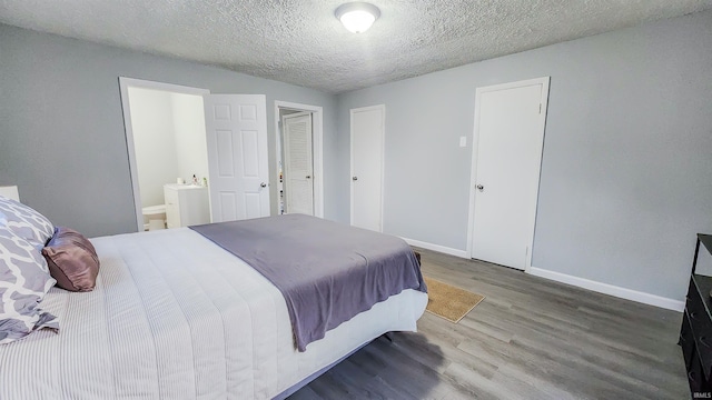 bedroom featuring ensuite bathroom, hardwood / wood-style floors, and a textured ceiling