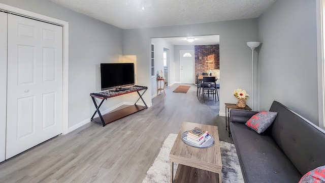 living room with light hardwood / wood-style flooring and a textured ceiling