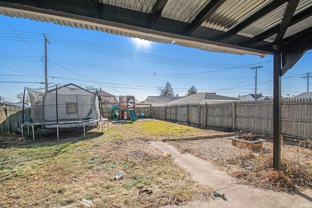 view of yard featuring a playground and a trampoline