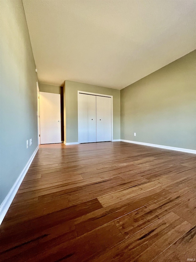 unfurnished bedroom featuring wood-type flooring and a closet