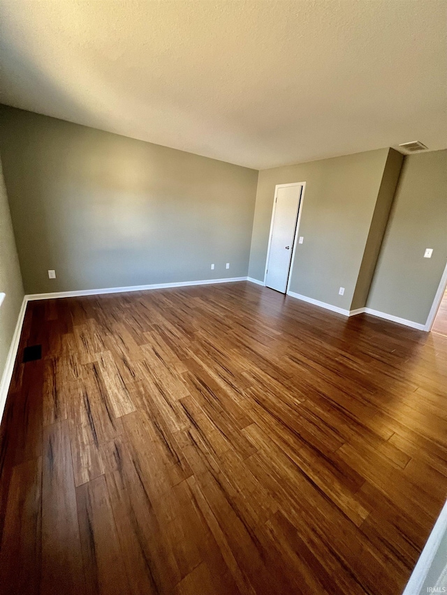 unfurnished room featuring wood-type flooring and a textured ceiling