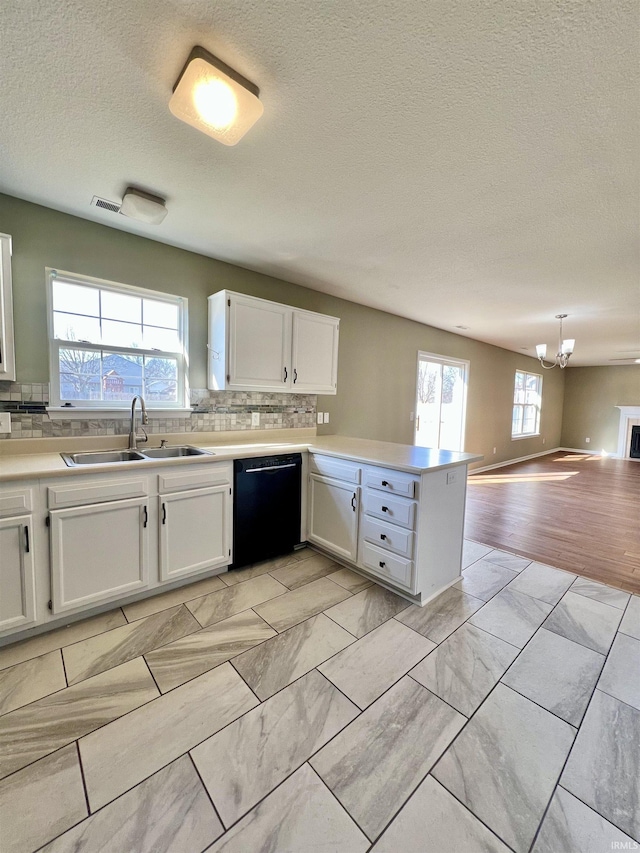 kitchen with sink, white cabinetry, decorative light fixtures, dishwasher, and kitchen peninsula