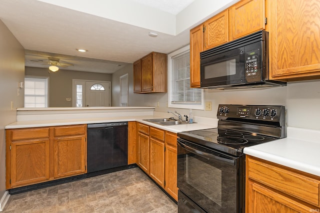 kitchen with ceiling fan, kitchen peninsula, sink, and black appliances