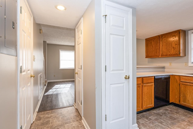 kitchen with a textured ceiling, electric panel, and black dishwasher