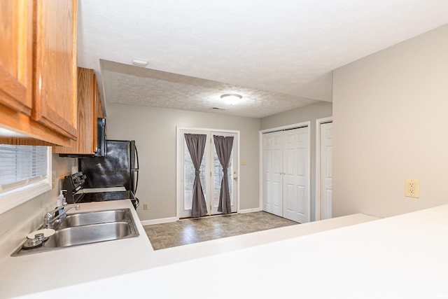 kitchen with range, sink, and a textured ceiling