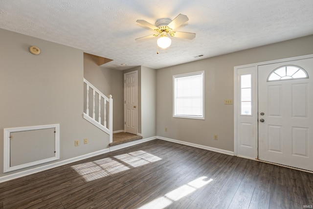 foyer entrance with ceiling fan, dark hardwood / wood-style flooring, and a textured ceiling