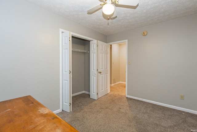 unfurnished bedroom featuring ceiling fan, a closet, carpet, and a textured ceiling