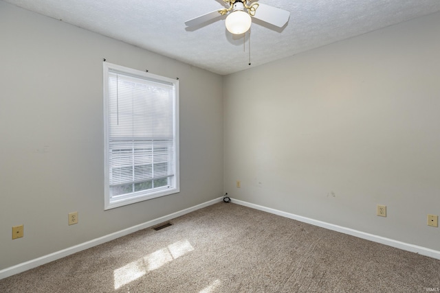 carpeted empty room featuring ceiling fan and a textured ceiling