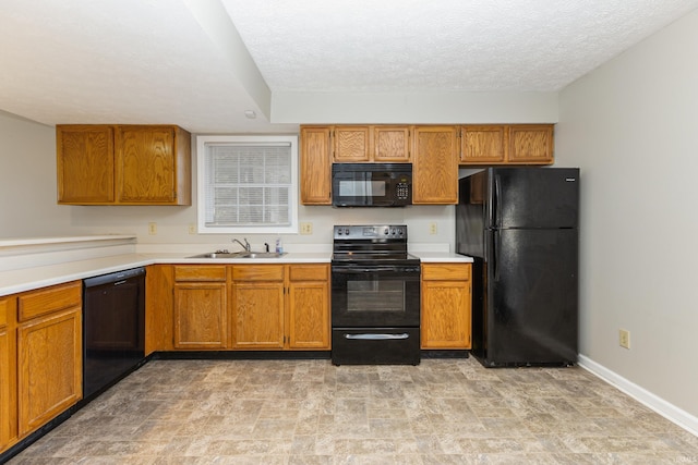 kitchen with sink, black appliances, and a textured ceiling