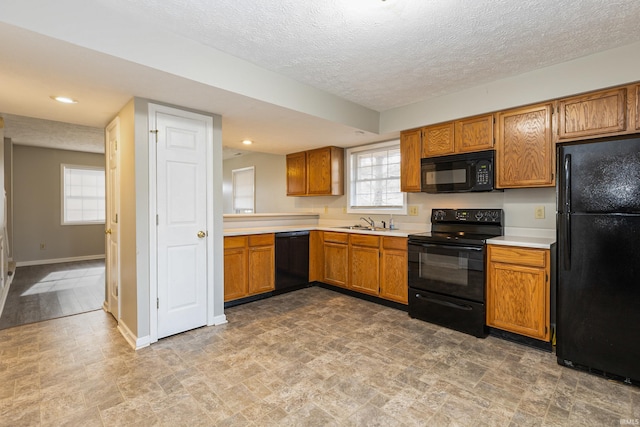 kitchen with sink, a textured ceiling, and black appliances