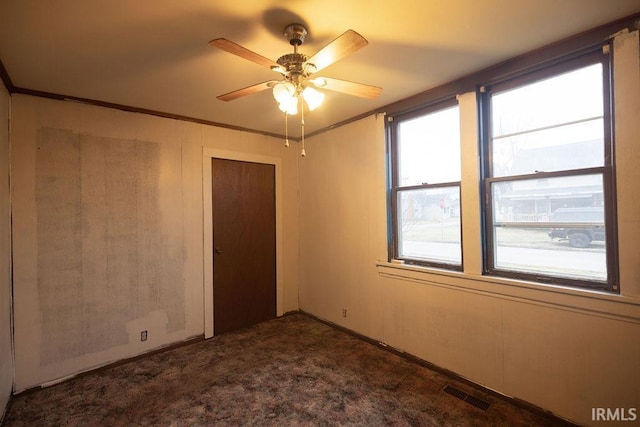 carpeted empty room featuring crown molding and ceiling fan