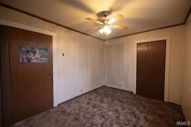 unfurnished bedroom with crown molding, ceiling fan, and dark carpet