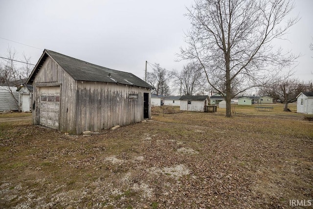 view of yard featuring a garage and an outdoor structure