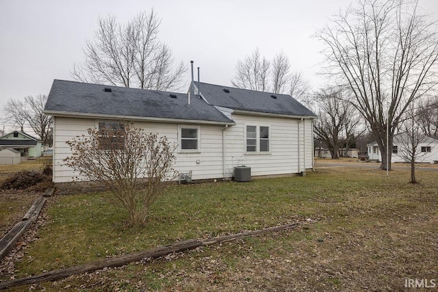 back of house featuring a yard and central AC