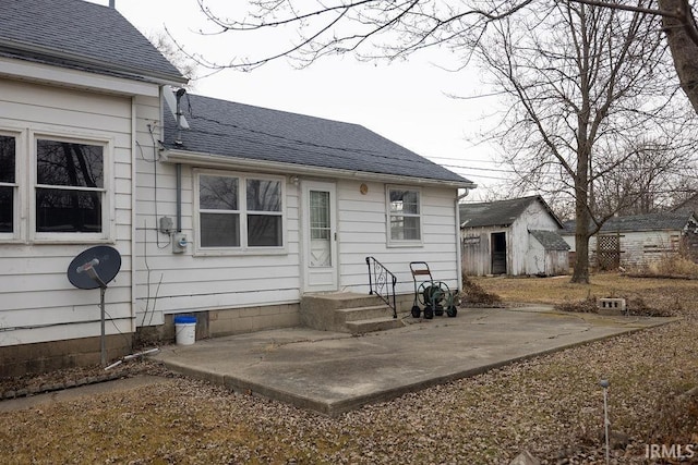 back of property featuring a storage unit and a patio area