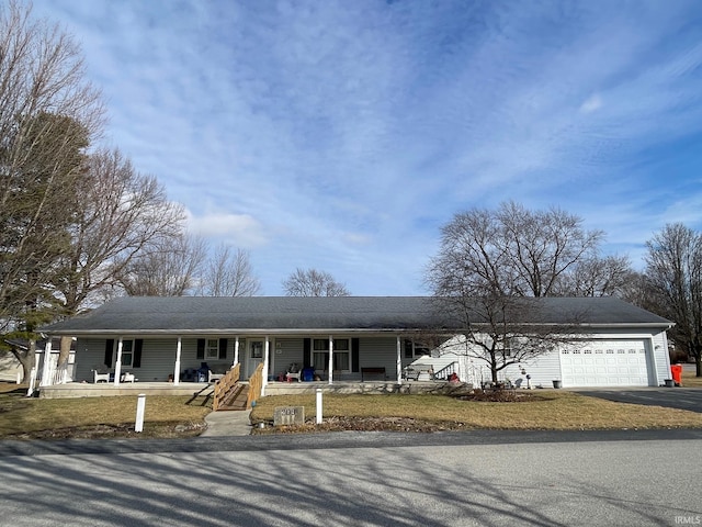 view of front of house featuring a garage, a front yard, and covered porch