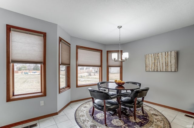 dining space featuring light tile patterned flooring and a notable chandelier