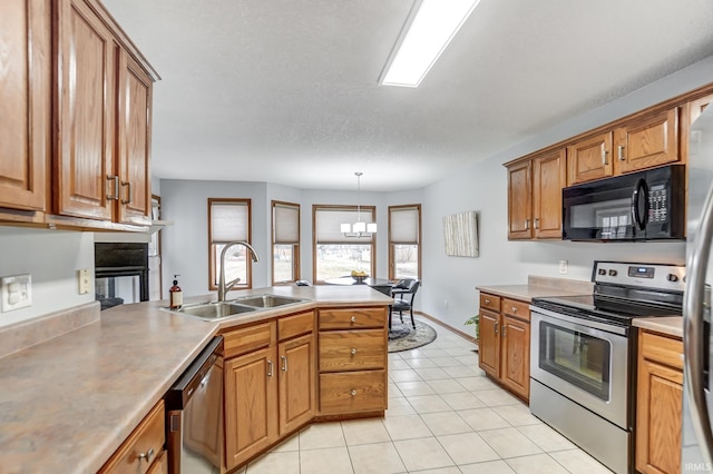 kitchen featuring sink, light tile patterned floors, appliances with stainless steel finishes, an inviting chandelier, and decorative light fixtures